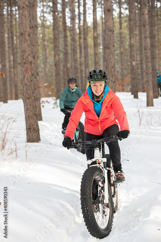 Obraz na płótnie Group of attractive women riding fat bikes in the snow w salonie
