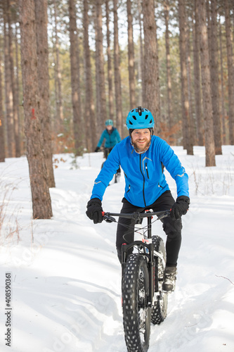 Obraz na płótnie Attractiveman ridesi his fat bike in the snow w salonie