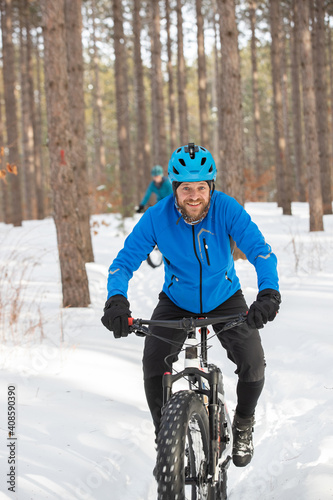 Obraz na płótnie Attractiveman ridesi his fat bike in the snow w salonie