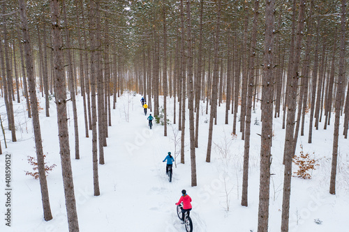 Obraz na płótnie Aerial photo of a group riding fat bikes in the snow w salonie