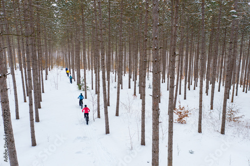 Obraz na płótnie Aerial photo of a group riding fat bikes in the snow w salonie