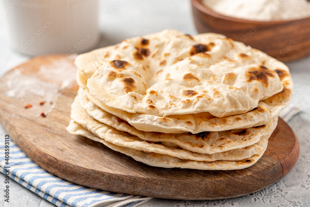 Homemade Roti Chapati Flatbread on a wooden board close-up. Freshly baked indian flatbread Homemade Roti Chapati Flatbread on a wooden board close-up. Freshly baked indian flatbread