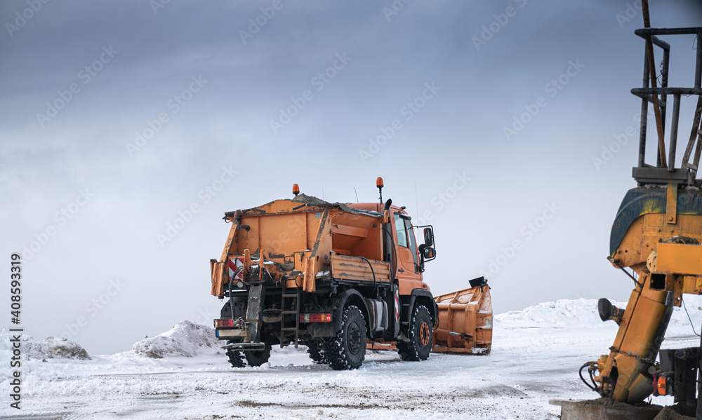 Snow plough truck cleaning a road through the mountains after winter massive snowfall Snow plough truck cleaning a road through the mountains after winter massive snowfall