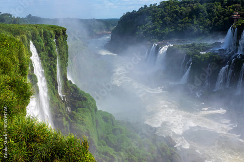 Wonderful vivid landscape of Iguazu Falls with water streams falling down among verdant vegetation in sunny day