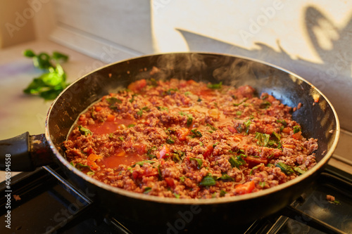 Spaghetti bolognese sauce being fried on a pan