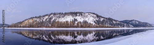 picturesque view of snow covered trees on riverside at sunrise © photollurg