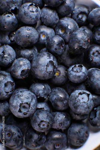 Blueberries close up on a plate. Fresh blueberries with water drops in macro.