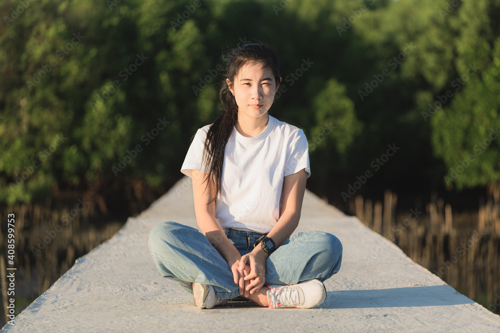 Obraz premium Young Asian woman with backpack standing and looking for something in the park.