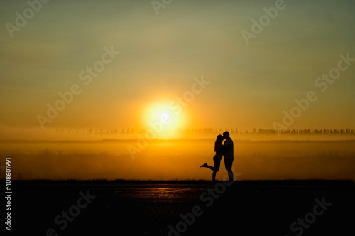 young couple of lovers kiss at sunset.