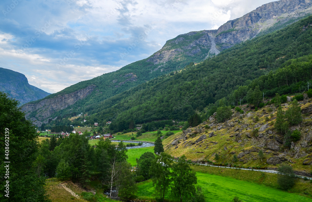 Amazing nature view to Norwegian village with fjord, mountain river and colorful houses at Flam, Sognefjord, Norway. Beautiful Scandinavian nature