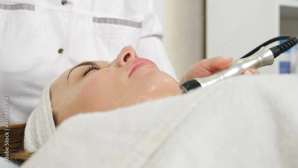 Cosmetologist making biolifting rf-lifting procedure. Rejuvenating skin, preventing aging, woman getting stimulating beauty facial treatment. hardware cosmetology in modern clinic. 4 k video Cosmetologist making biolifting rf-lifting procedure. Rejuvenating skin, preventing aging, woman getting stimulating beauty facial treatment. hardware cosmetology in modern clinic. 4 k video