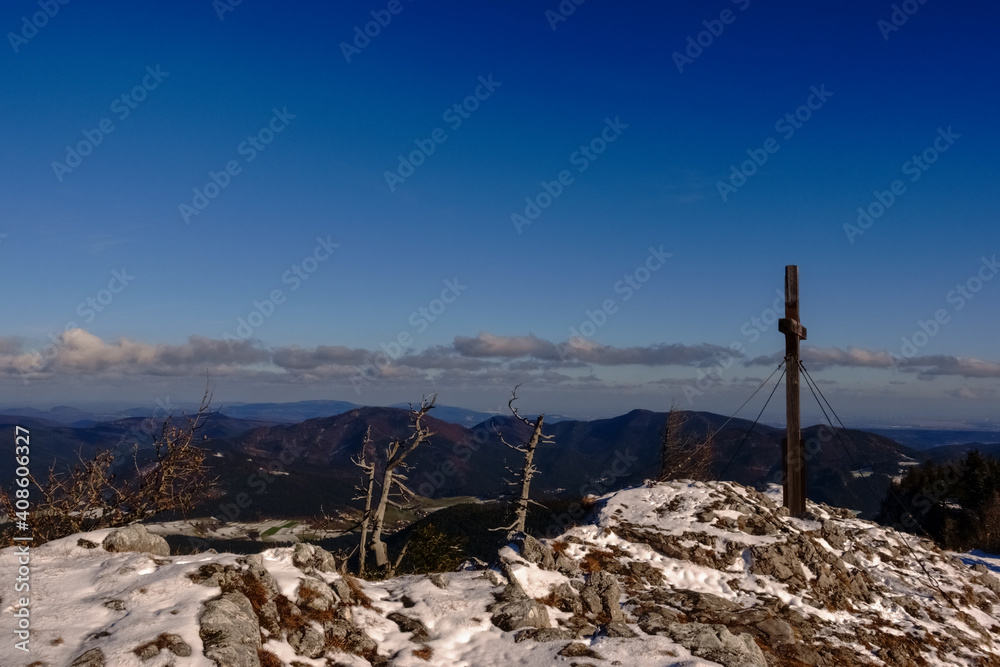 summit cross and gnarled tree trunks on a mountain while hiking