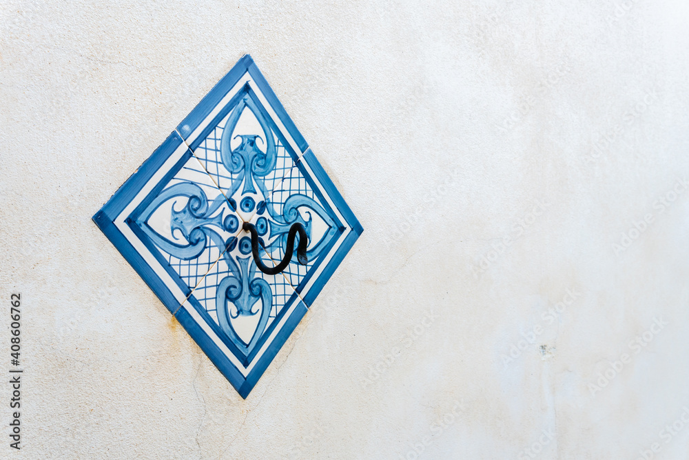 Antique tile with blue decoration on a white facade Antique tile with blue decoration on a white facade