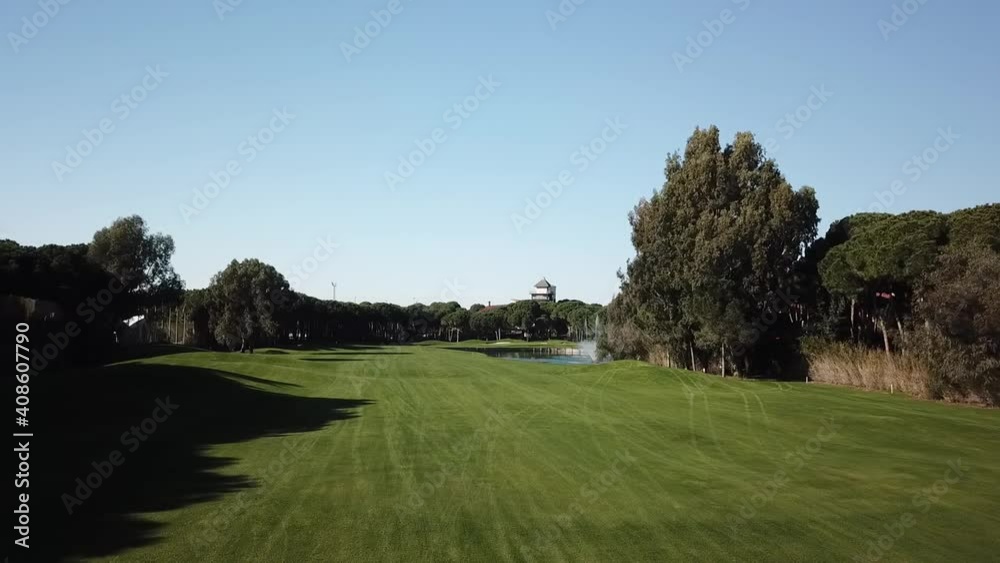 Drone slowly flying over vivid golf field in low angle shot Drone slowly flying over vivid golf field in low angle shot
