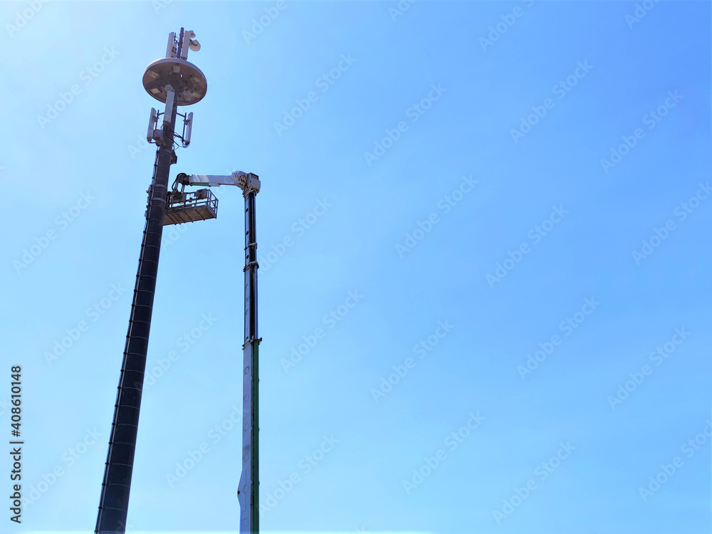 Telecommunication tower with antennas against blue sky background with copy space.