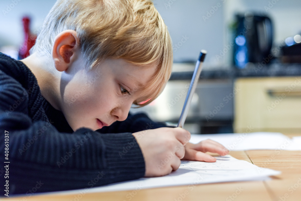Child doing homework at the kitchen table at home during lockdown Child doing homework at the kitchen table at home during lockdown