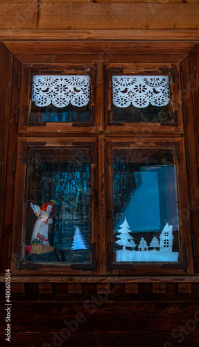 Vintage brown country wooden window. Antique traditional building exterior detail. Travel photo. Retro rustic wood boards. Natural wood texture  weathered wall. Ornamental pattern facade design.