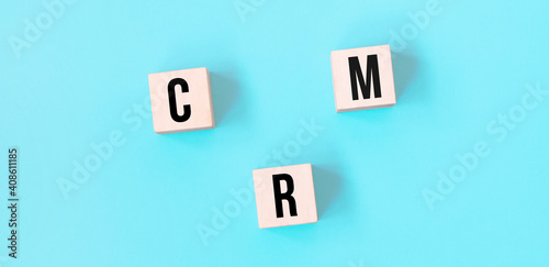 Concept word CRM business to business on cubes on a beautiful blue background. Business concept. Copy space.