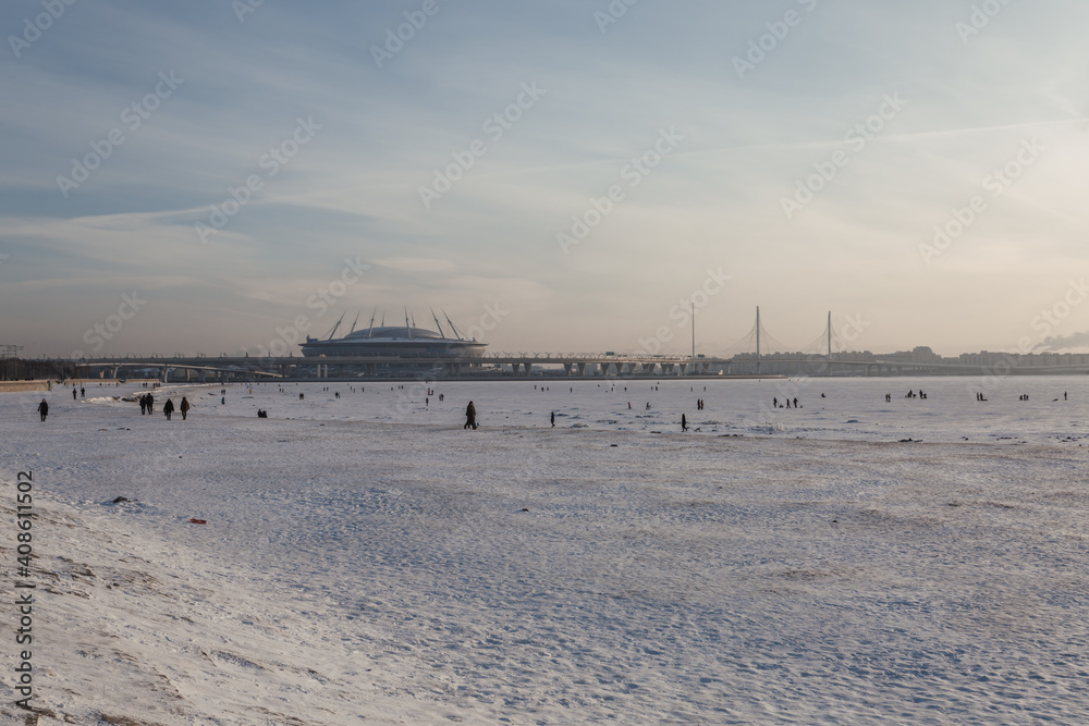 Scenic view on the stadium and people walking on the icy shore of the Finnish Gulf. Scenic view on the stadium and people walking on the icy shore of the Finnish Gulf.