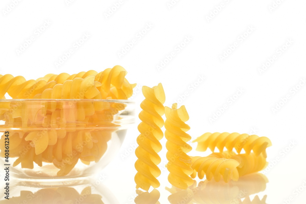 Bright yellow uncooked Fusilli pasta in a glass plate, close-up, isolated on white. Bright yellow uncooked Fusilli pasta in a glass plate, close-up, isolated on white.