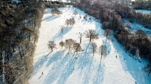 Snow covered public park and wood land forest scene from aerial drone