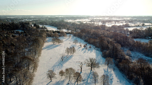 Snow covered public park and wood land forest scene from aerial drone