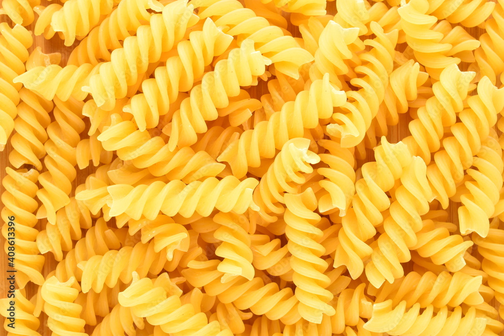 Bright yellow uncooked Fusilli pasta, close-up, top view. Bright yellow uncooked Fusilli pasta, close-up, top view.