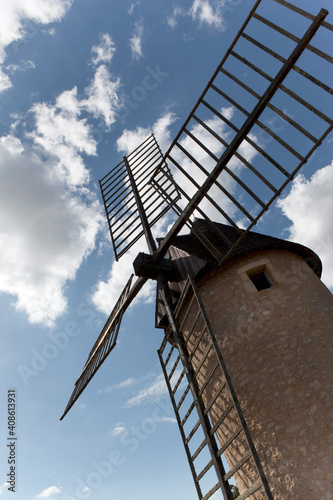 Old windmill and cloudy sky on background