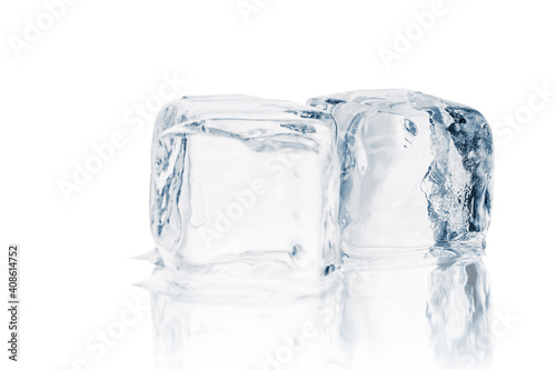 Melting natural crystal clear ice cubes on a white reflective surface. 