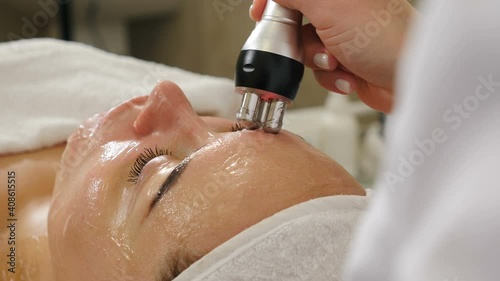 Cosmetologist making biolifting rf-lifting procedure. Rejuvenating skin, preventing aging, woman getting stimulating beauty facial treatment. hardware cosmetology in modern clinic. 4 k video