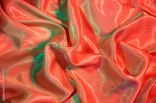 Smooth elegant Silk fabric in neon green and red lights. Texture, background, copy space