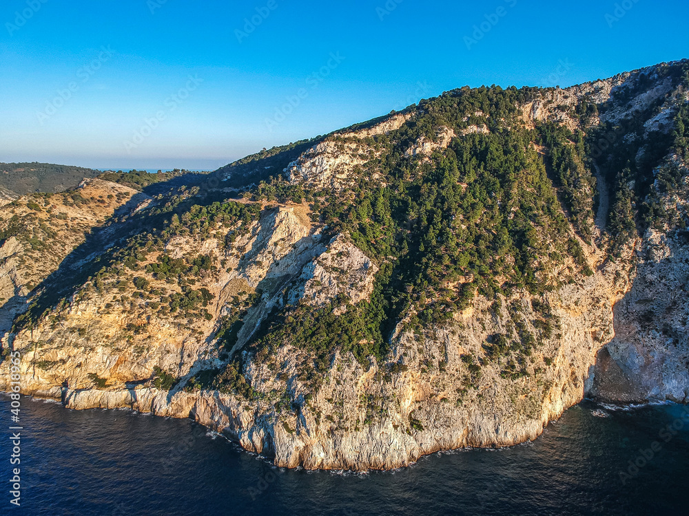 Aerial drone view over western Alonnisos towards Skopelos island at sunset. Natural landscape, beautiful rocky scenery, in Sporades, Aegean sea, Greece