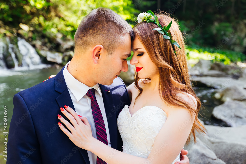 newlyweds in love in nature. Stylish groom in a blue suit and a newlyweds in love in nature. Stylish groom in a blue suit and a