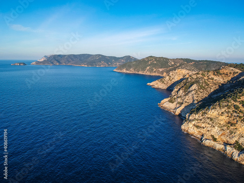 Aerial drone view over western Alonnisos towards Skopelos island at sunset. Natural landscape, beautiful rocky scenery, in Sporades, Aegean sea, Greece