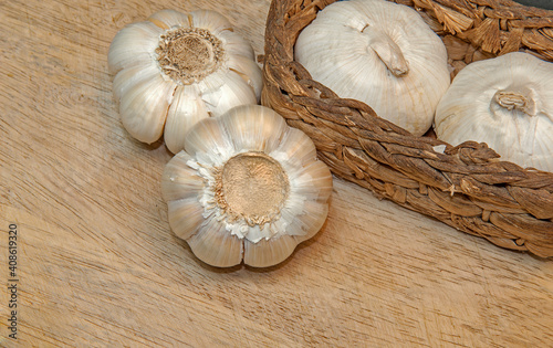 Healthy and wholesome food. Fresh garlic in a wicker basket on a wooden background. Selective focus. Top side view.