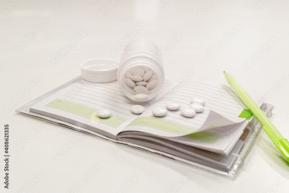 The pills are scattered on a notebook. The pills are scattered on a notebook.