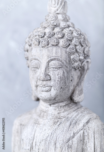 Meditating Buddha Statue on bright background. 