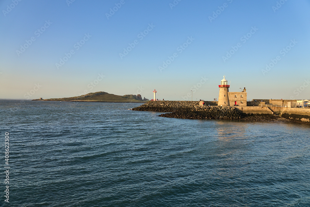 Beautiful view of Howth lighthouse and Ireland's Eye with perfectly clear evening blue sky viewed from Howth harbor, Dublin, Ireland
