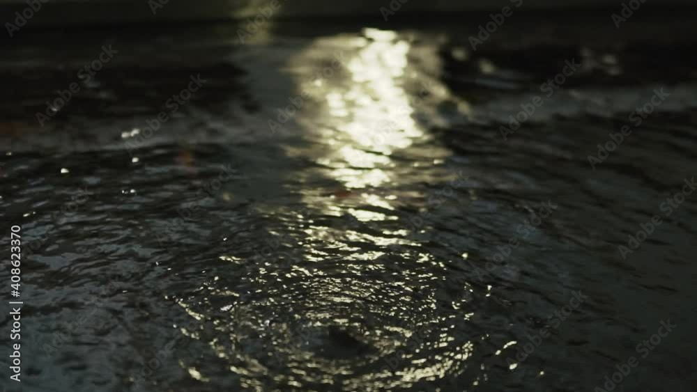 Close-up of small interior fountain with pool illuminated by light. Aquarium fish swim in water Close-up of small interior fountain with pool illuminated by light. Aquarium fish swim in water