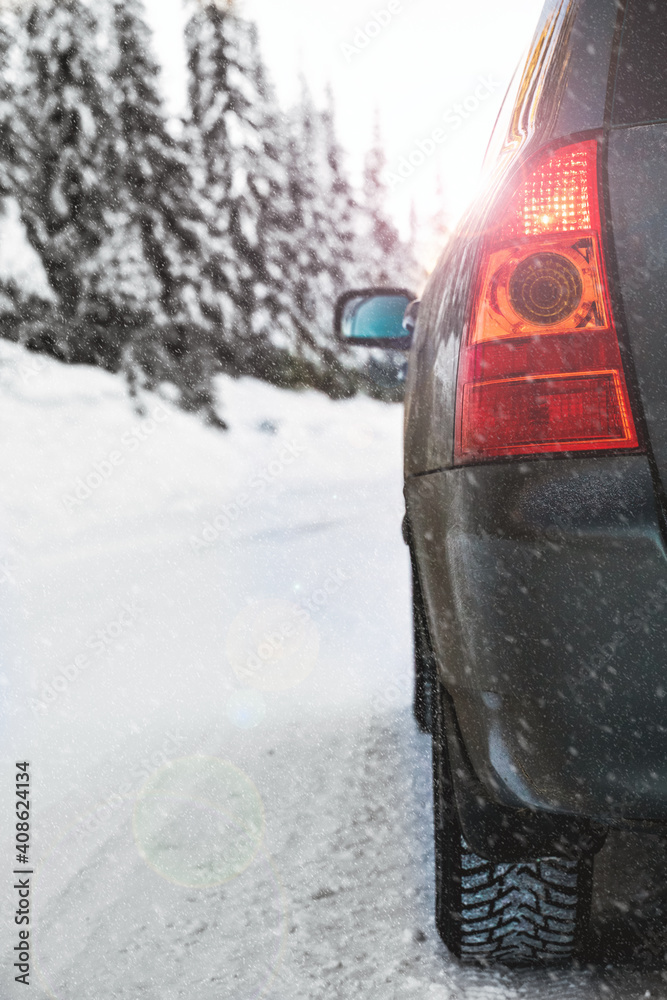 Car driving on a winter road in the snow. Close up, shallow depth of field.