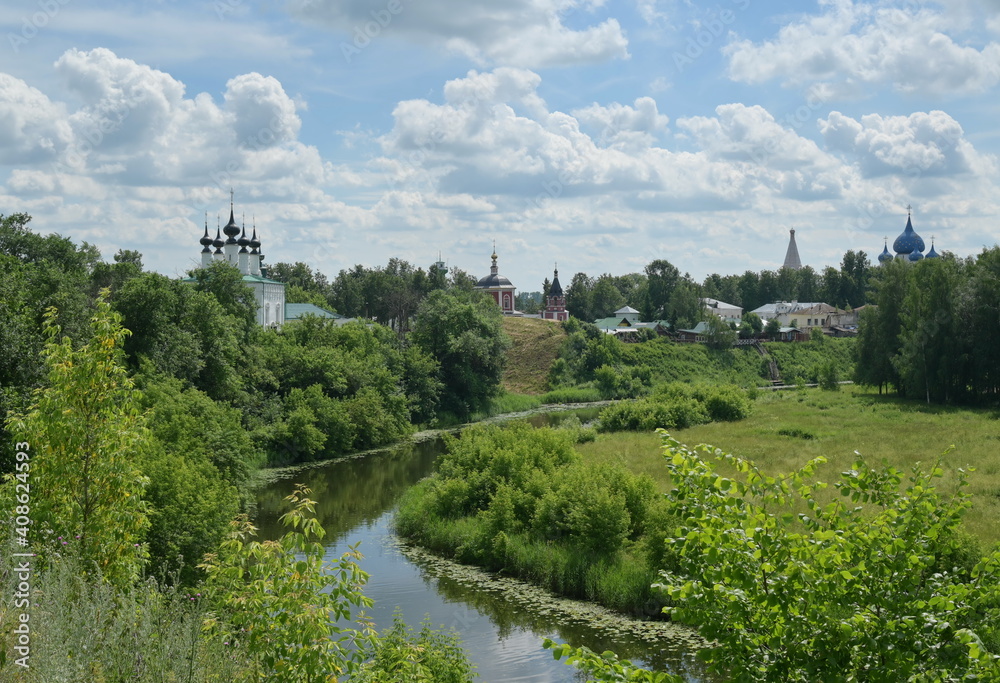 Orthodox Russian churches standing along the river, pleasant summer village landscape. The 