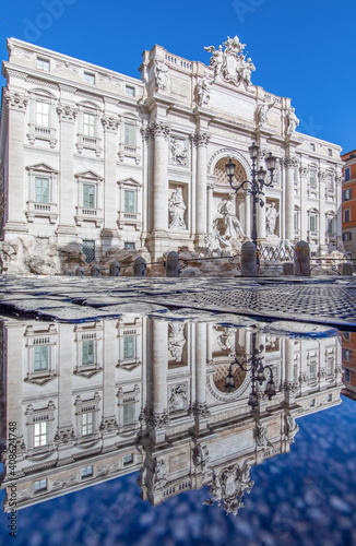 Rome, Italy - in Winter time, frequent rain showers create pools in which the wonderful Old Town of Rome reflect like in a mirror. Here in particular the Trevi Fountain