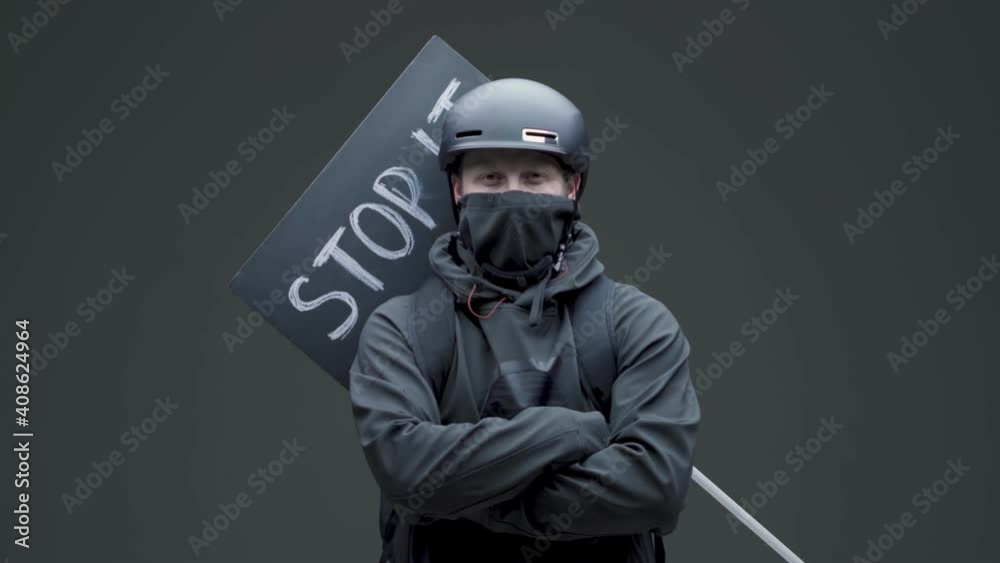 Protestor guy with cardboard tablet with inscription stop it posing on gray background. Protests in America Protestor guy with cardboard tablet with inscription stop it posing on gray background. Protests in America