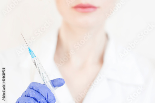 Hand holding syringe and vaccine.