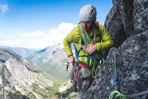 Man sorting through gear on harness while rock climbing in Washington photo