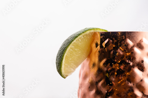 Cocktail in a short copper tumbler topped with fruid photo