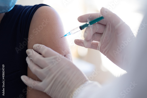 Close up of a Doctor making a vaccination in the shoulder of patient  Flu Vaccination Injection on Arm  coronavirus  covid-19 vaccine disease preparing for human clinical trials vaccination shot.