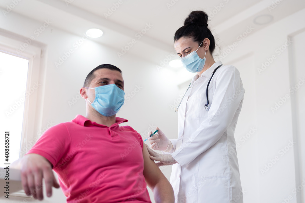 Close up of a Doctor making a vaccination in the shoulder of patient, Flu Vaccination Injection on Arm, coronavirus, covid-19 vaccine disease preparing for human clinical trials vaccination shot. Close up of a Doctor making a vaccination in the shoulder of patient, Flu Vaccination Injection on Arm, coronavirus, covid-19 vaccine disease preparing for human clinical trials vaccination shot.