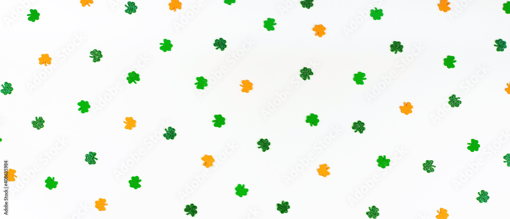 Banner with green orange and white shamrock confetti sparse on white background Happy St. Patrick's Day Spring 17 march backdrop in Irish flag colors with lucky clovers