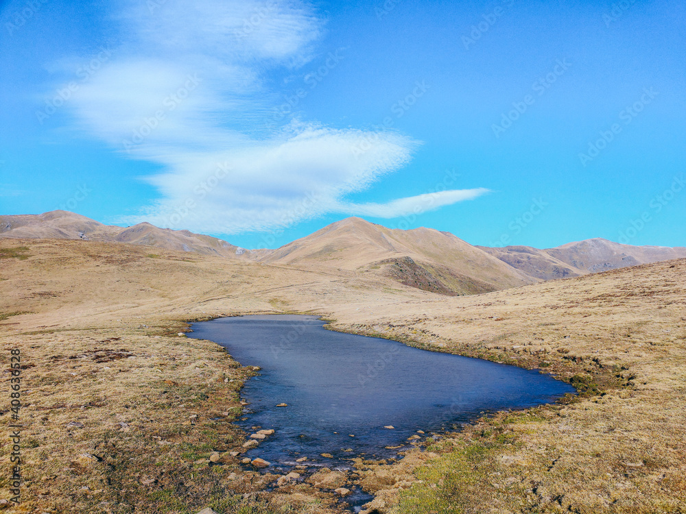 Small natural lake on a high mountain landscaping. Concept of hiking in the mountains, mountaineering, natural landscape. Balandrau mountain in Ripolles, Pirineus-Pyrenees Range, Catalunya, Spain.